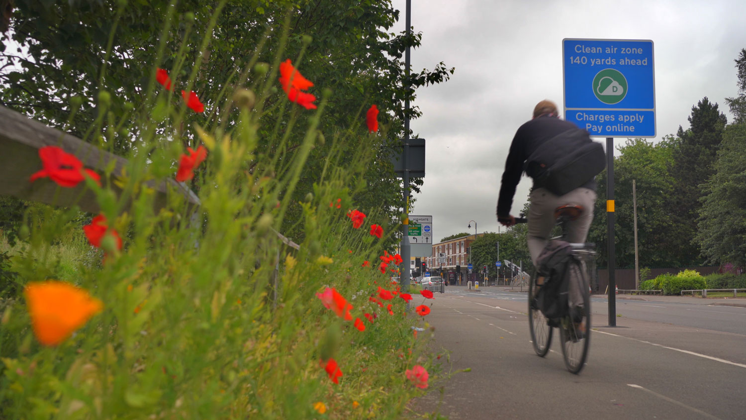 Cyclist passing a Clean Air Zone sign in Birmingham Cyclist passing a Clean Air Zone sign in Birmingham